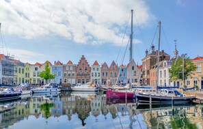 Ein Kanal mit vertäuten Booten, umgeben von farbenfrohen Gebäuden mit traditioneller Architektur.