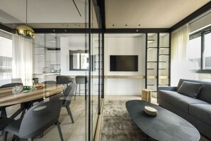 A modern interior with a dining area, sofa, and TV.