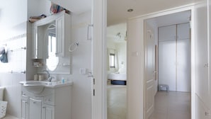 A modern bathroom with a vanity, mirror, and a walk-in shower. - Bright 3BR Stay • Relaxing Comfort (Tel Aviv-Yafo)