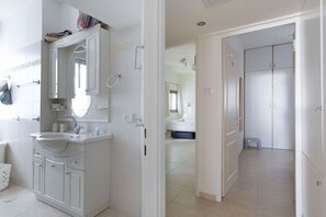 Une salle de bain moderne avec un lavabo, un miroir et des placards.