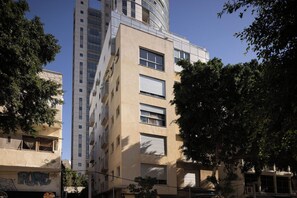 Un edificio a più piani con un design architettonico moderno, caratterizzato da balconi e ampie finestre.