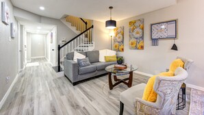 A modern living room with a staircase, a sofa, a chair, and a coffee table. - Modern Boho Retreat W/3 Spacious Bedrooms +3Bathrooms +Garage (Houston)