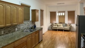 A kitchen with wooden cabinets, a granite countertop, and a built-in dishwasher.