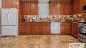 A kitchen with wooden cabinets, a white refrigerator, a dishwasher, a stove, and granite countertops. - Downtown Extended Stay ~ Try Purple Mattress Brand - Middlesex County (South Plainfield)