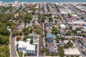 Stroll through a charming neighborhood with a mix of modern and traditional homes, surrounded by trees and a waterfront.