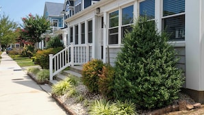 A row of two-story houses with white railings and a well-maintained garden. - Coastal Condo Close to Beach & Entertainment (Rehoboth Beach)