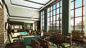 Un vestíbulo amplio con zona de bar, asientos y grandes ventanales que ofrecen vistas al exterior.