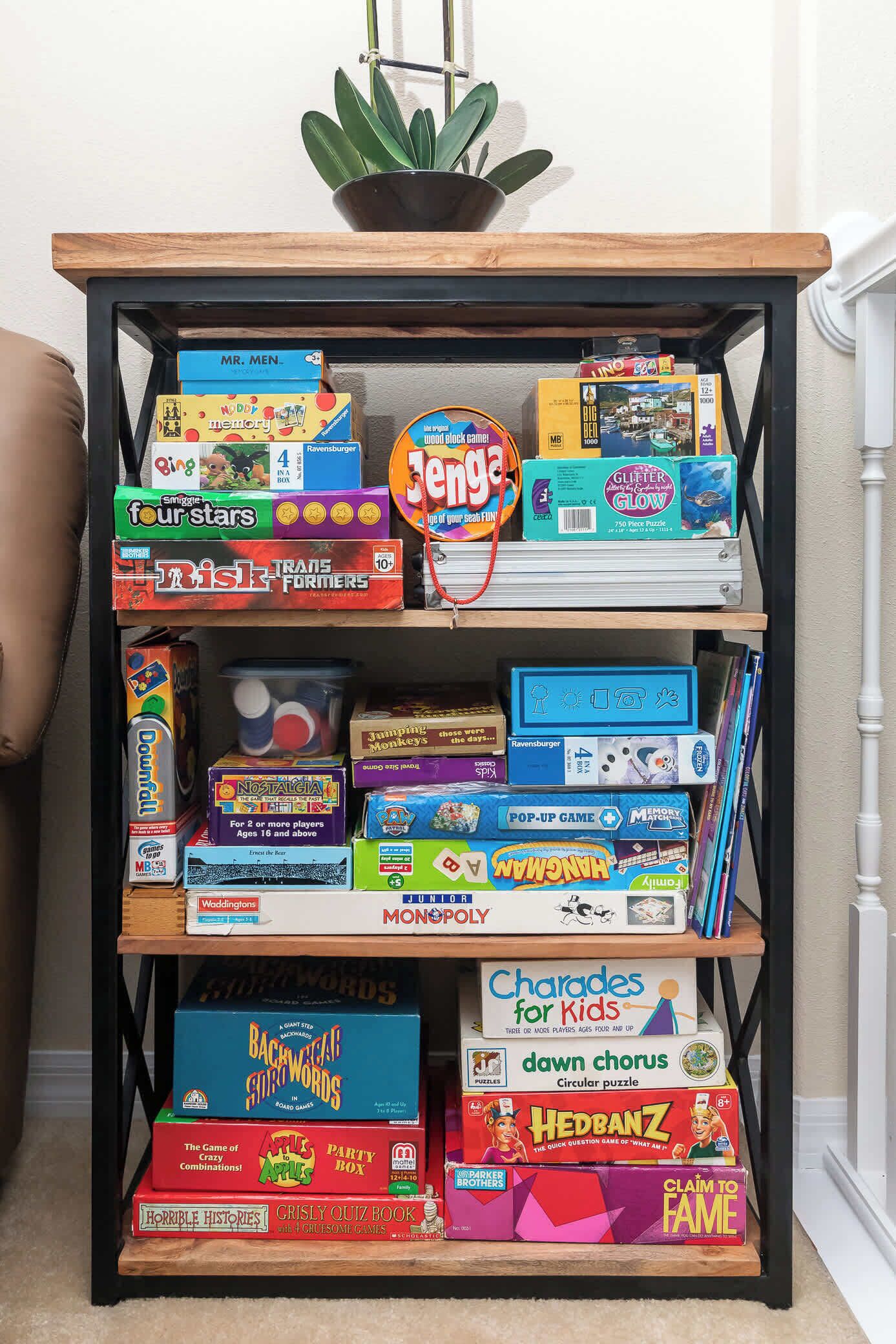 A bookshelf filled with various board games and puzzles.