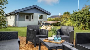 An outdoor seating area with wicker furniture and a tray with drinks and snacks. - Nice home in Kerteminde with WiFi (Kerteminde)