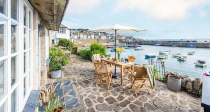 A beautifully refurbished stone cottage that sits right on Mousehole Harbour's waters edge.
