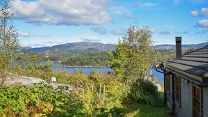 Une cabane avec vue sur un lac et des montagnes.