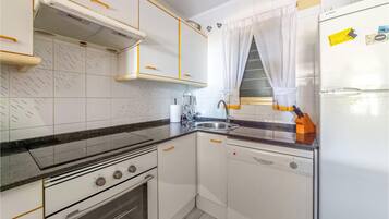 Een koelkast, een oven, een kookplaat, een vaatwasser