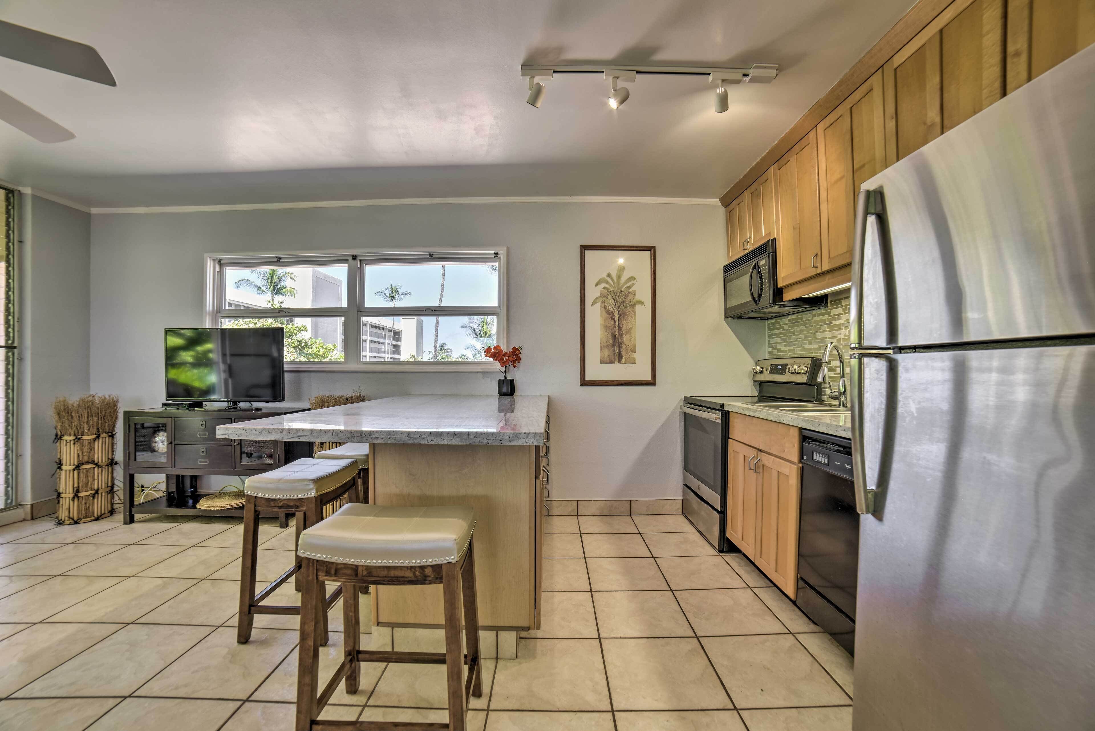 A modern kitchen with a central island, wooden cabinets, stainless steel appliances, and a large window providing natural light.