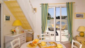 Un comedor con una mesa dispuesta para el desayuno, una escalera y vistas al exterior.