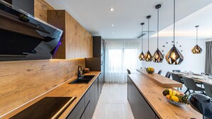 A modern kitchen with wooden cabinetry, a built-in oven, and a central island with a sink. - Gorgeous home in Marina (Marina)