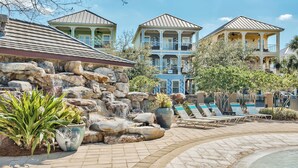 Un resort con zona de piscina, sillones de descanso y una cascada.