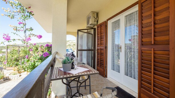 A balcony with a table and chairs, a potted plant, and a view of the surrounding landscape. - Gorgeous apartment in Kanica with WiFi (Kanica)