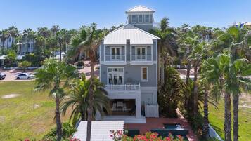 A two-story building with a balcony, surrounded by palm trees.