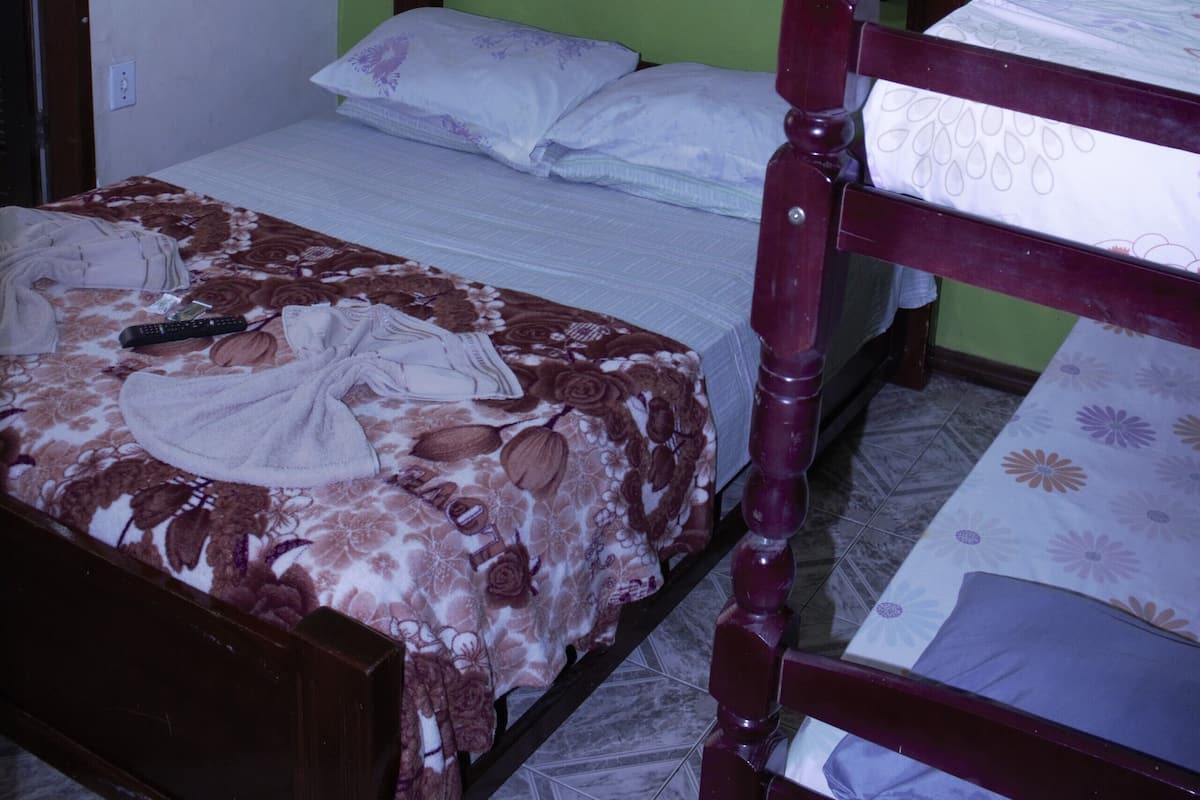 Une chambre avec un lit, un ventilateur de plafond et un climatiseur.