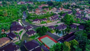 An aerial view of a residential area with houses, a tennis court, and a church with multiple spires.