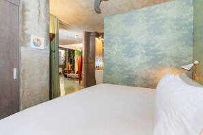 A hotel room with a large bed, a view of the hallway, and a door leading to another room. - Large loft with balcony and great city view (Barranquilla)