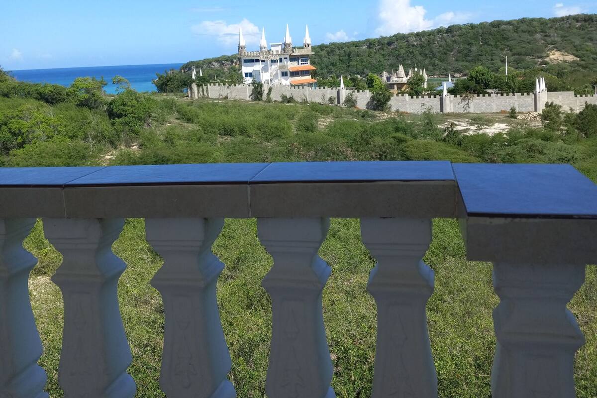 A castle with multiple towers and a sea view.