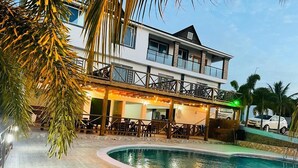 Un hôtel moderne doté d’une piscine, d’un espace extérieur aménagé et d’une structure à deux étages.