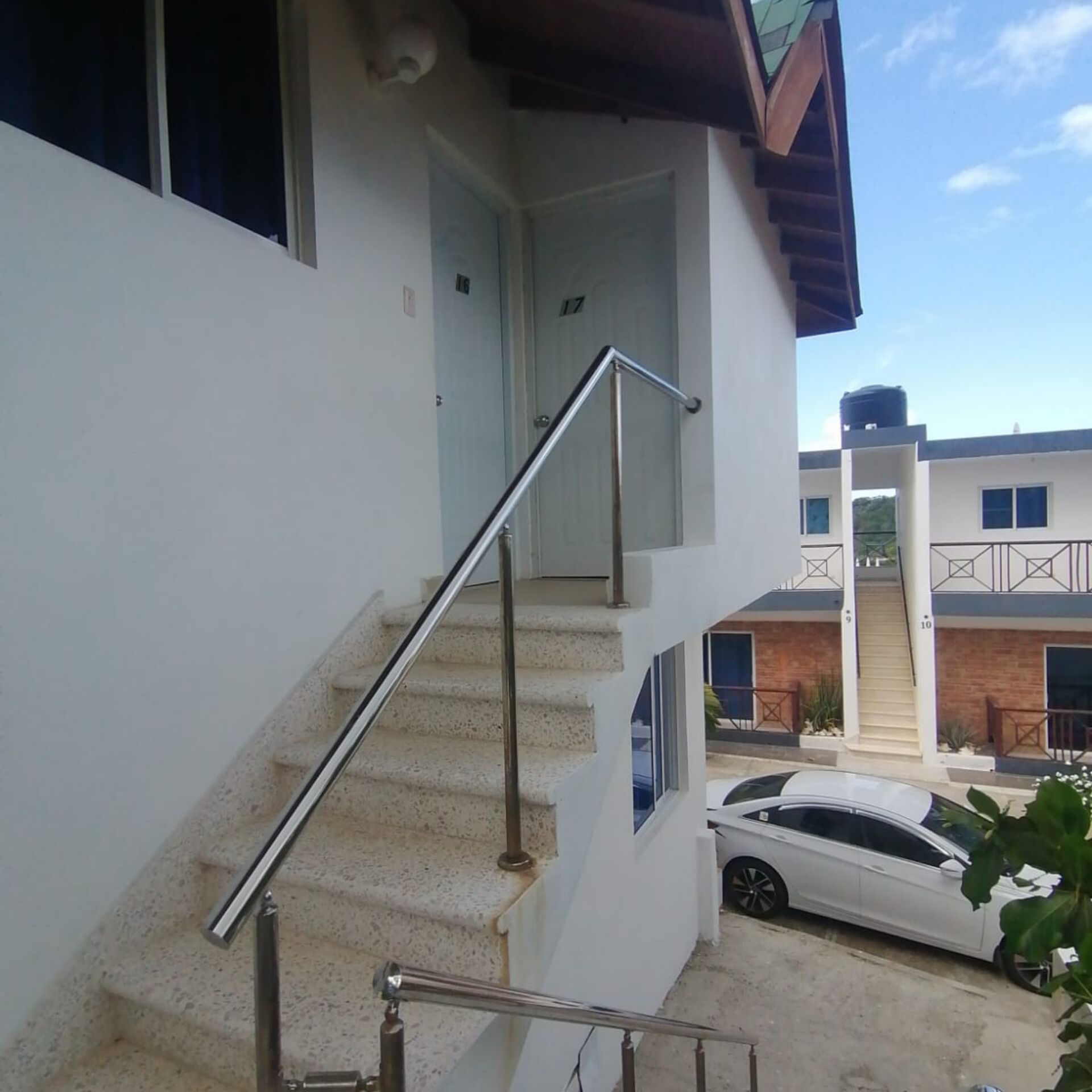 A residential building with a staircase leading to a door marked with the number 17.
