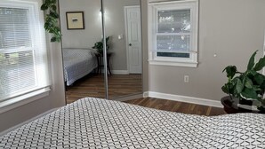 A bedroom with a bed, a window, a door, and a mirror. - Entire 3 bedrooms/2 bathrooms fence yard, near Costco, Sam's (Gaithersburg)