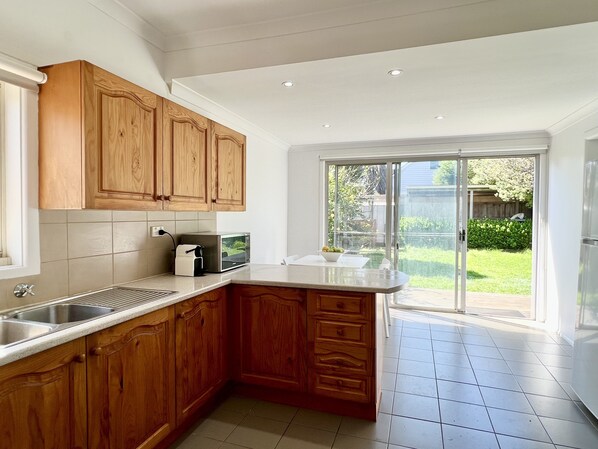 A kitchen with wooden cabinets, a microwave, and a sink.