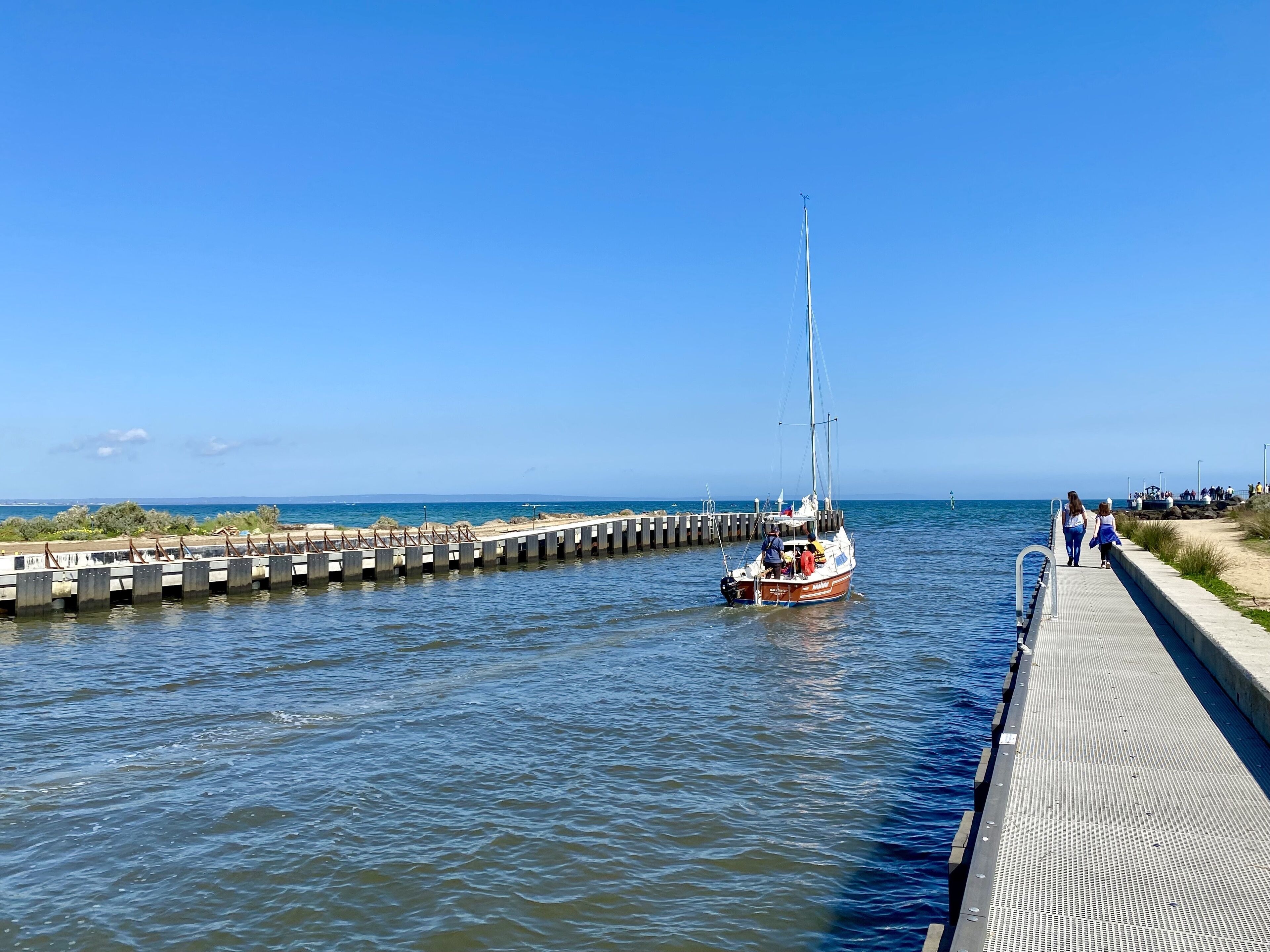 A boat docked at a pier with a clear blue sky.