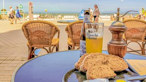 Un tavolo con una bottiglia di Blanc de Namur, un bicchiere di birra e fette di pane.