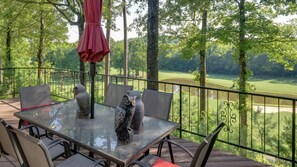 A deck with a glass table, chairs, and an umbrella. It overlooks a golf course. - Beautiful home, 1/4 mile from Balboa Beach/Marina (Hot Springs Village)