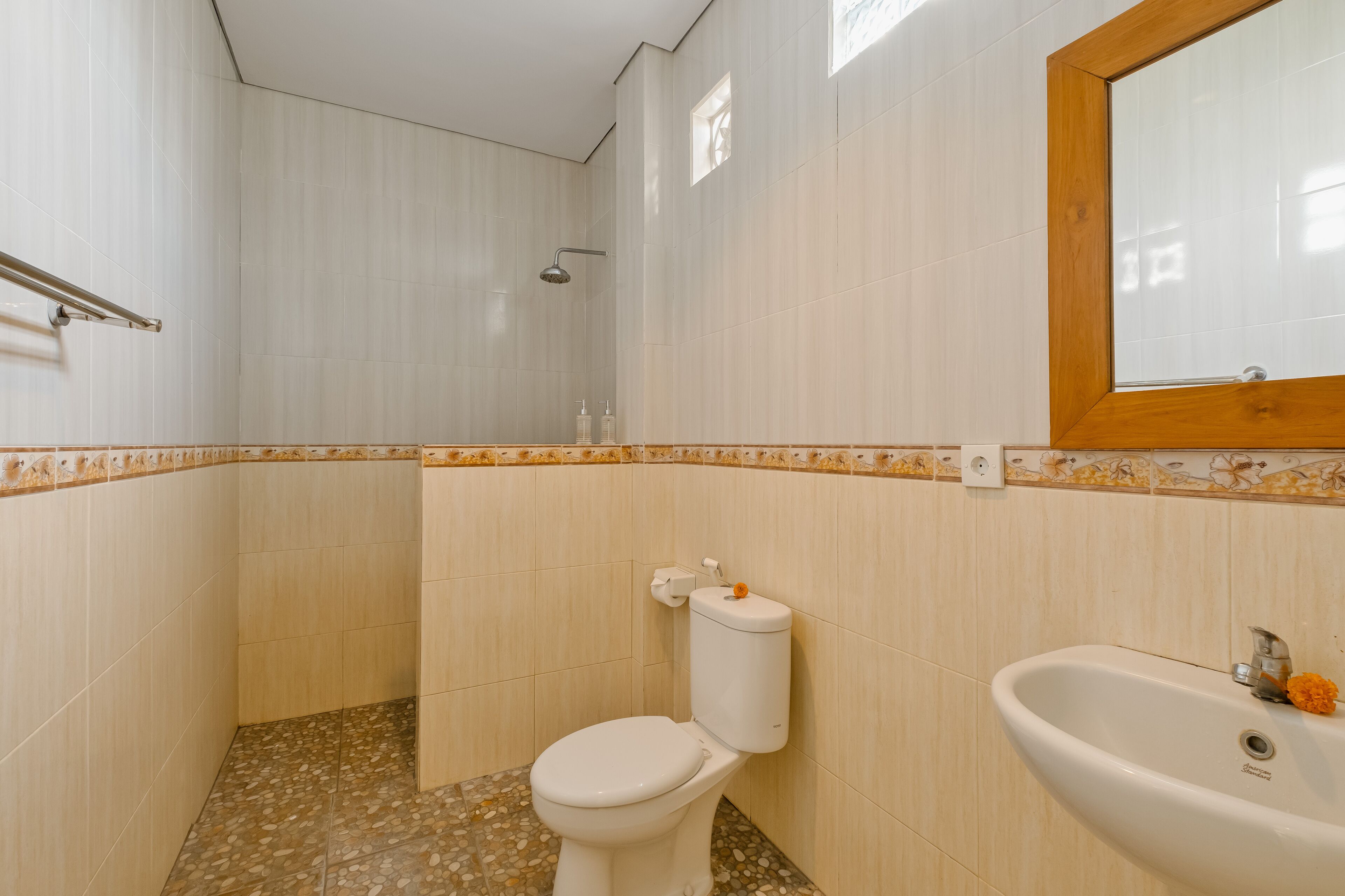 Une salle de bain avec des toilettes, un lavabo et une douche.