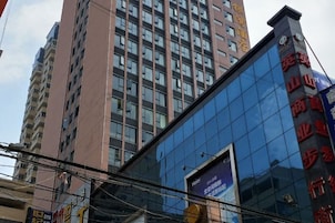 Un edificio moderno con fachada de vidrio y señalización que indica que es un hotel.