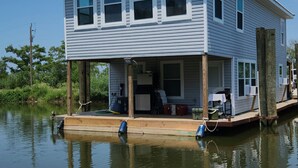 A houseboat with a covered deck, windows, and a small porch area. - Rusty Hook located in Cypress Cove Marina   (Venice)
