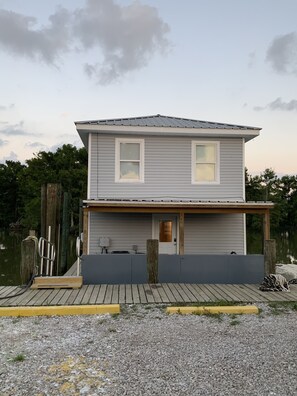 A two-story house with a front porch, a dock, and a small deck area. - Rusty Hook located in Cypress Cove Marina (Venice)