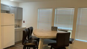 A compact kitchen with a dining table, two chairs, and a sign on the table. - Rusty Hook located in Cypress Cove Marina   (Venice)