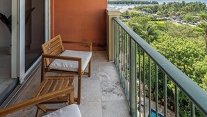 A balcony with two wooden chairs and a small pool. - Coconut Grove Retreat, bayviews, 1 park incl, wkspace, Smart TV, Pool/hottub" (Coconut Grove)