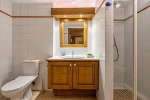 A bathroom with a toilet, sink, mirror, and shower. - Chalets d'Henri 67 Apartment w/ Terrace & Mont Blanc Views, Argentière (Chamonix), France (Argentière (Chamonix))