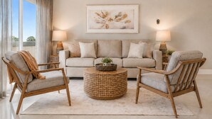 A living room with a sofa, two armchairs, a coffee table, and a painting on the wall. - Beach House 85-Just One House from the Sand! (Ventura)