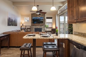 A kitchen with a central island, a dining area, a sofa, and a ceiling fan. - Trailhead 232  pool, hot tub, clubhouse (Winter Park)
