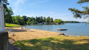 A lakeside view with a sandy beach, a dock, and a row of trees. - Relaxing Executive Condo at Big Bear Resort - Kentucky Lake views (Benton)