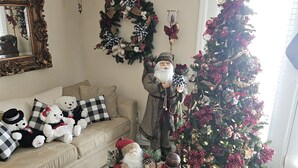 A living room with a Christmas tree, a sofa with plush toys, and a decorative mirror. - Relaxing Executive Condo at Big Bear Resort - Kentucky Lake views (Benton)