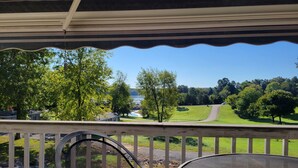 A covered outdoor area with a view of a green landscape and a body of water. - Relaxing Executive Condo at Big Bear Resort - Kentucky Lake views (Benton)