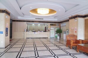 A hotel lobby with a reception desk, seating area, and a chandelier. - Jinglong International Hotel (Yanling)
