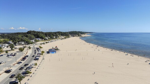 A beach with a parking area and a small building with a blue roof. - ❤ 5 Min Walk to Beach Fast Wi-Fi Arcade Games ❤ (Muskegon)