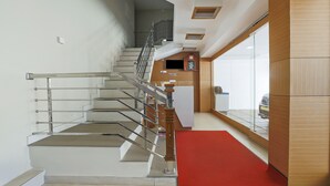 A modern interior with a staircase, a reception area, and a kitchen. - Itsy Hotels Kottaram Residency, 10 Mins To Botanical Garden (Ootacamund)