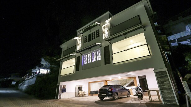 A two-story building with a car parked in the driveway and a motorcycle beside it. - Itsy Hotels Kottaram Residency, 10 Mins To Botanical Garden (Ootacamund)