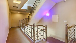 A modern staircase with metal railings and a purple-lit wall. - Itsy Hotels Kottaram Residency, 10 Mins To Botanical Garden (Ootacamund)